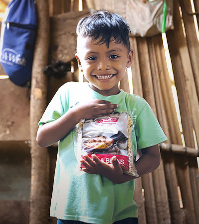 A little boy holds a bag of Vitafood.
