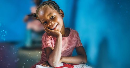 little girl smiling with her Box of Joy gift