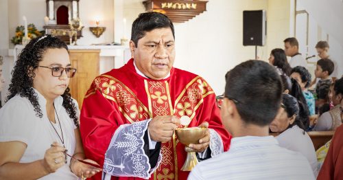 A priest serves the Eucharist.