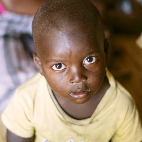 A little boy looks into the camera lens.