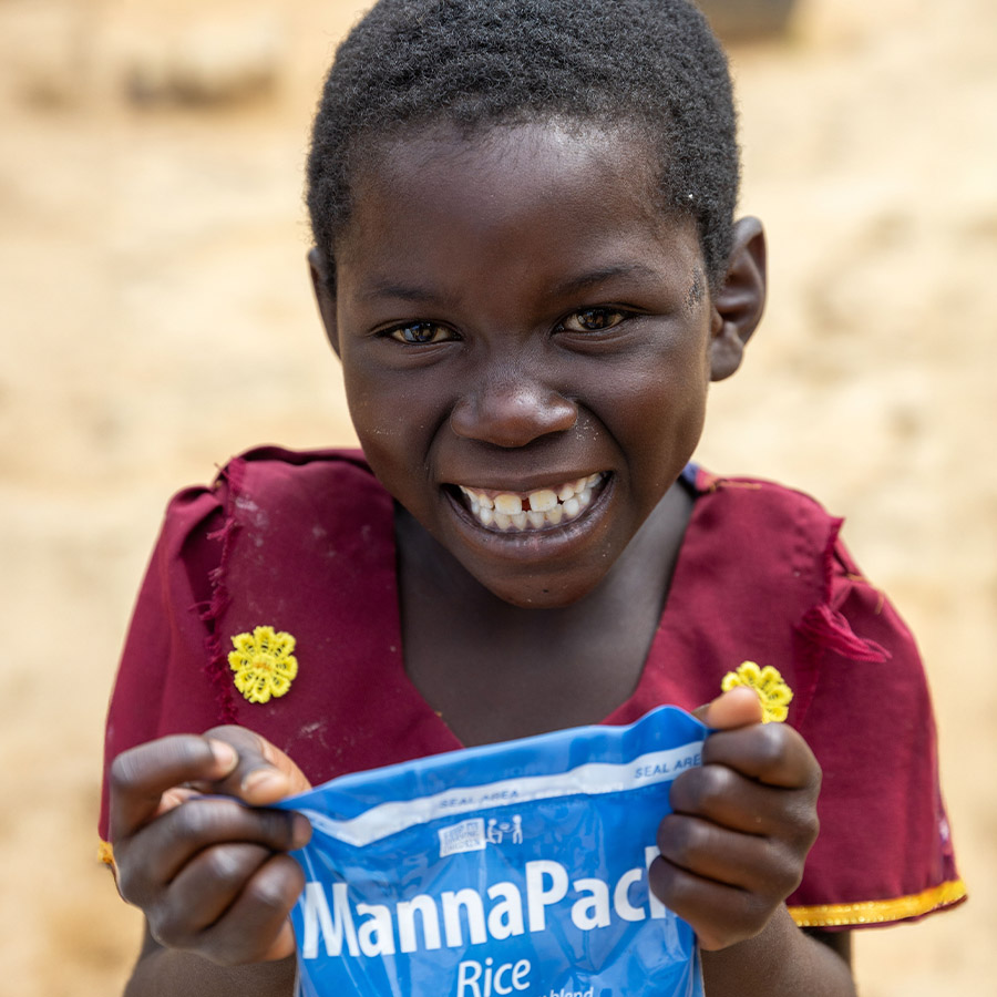 A Malawian girl holds a meal packet.