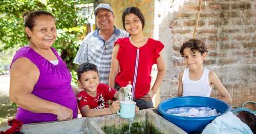 Una familia nicaragüense obtiene agua potable de una llave ubicada afuera del hogar de sus abuelos.