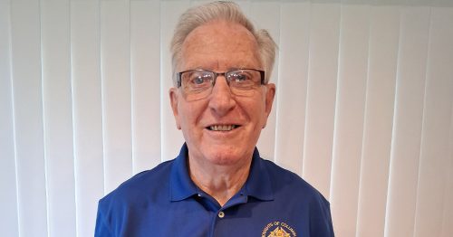 A man in glasses smiles at the camera.