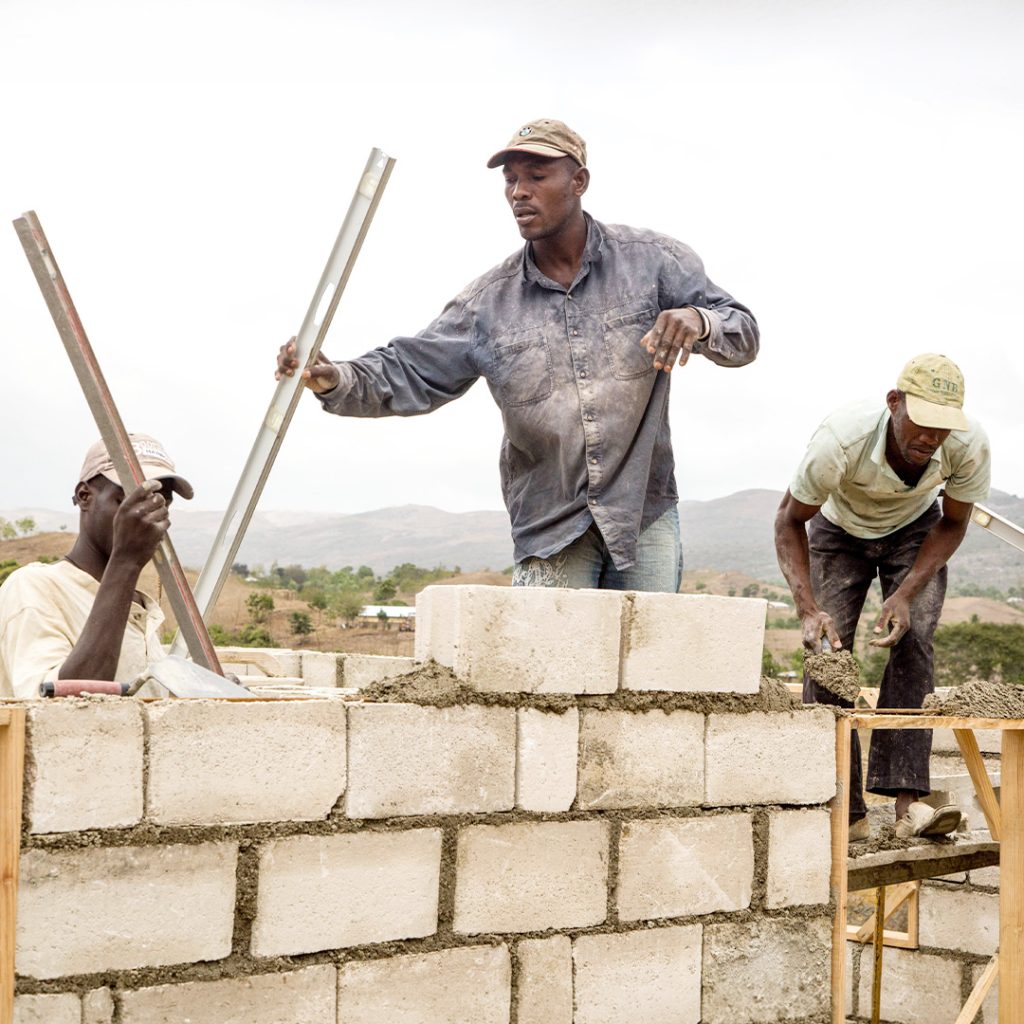 Workers build the walls of a home.