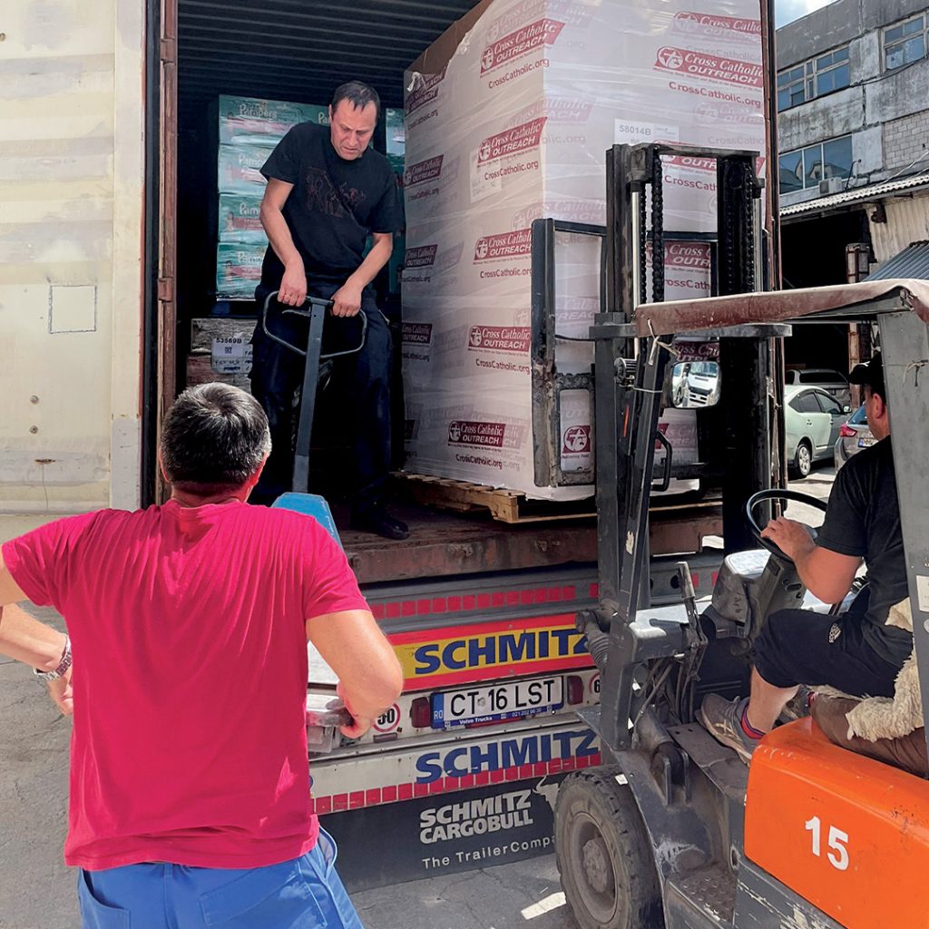 Two men unload a shipping container of Vitafood.