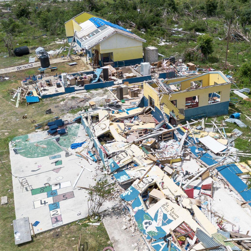 Aerial view of a destroyed elementary education building. One portion is still standing, but with major damage to the roof and walls.