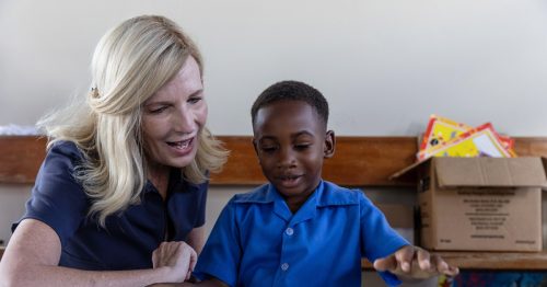 Cross Catholic Outreach President Michele Sagarino with a young student at St. Theresa Kindergarten in Jamaica.